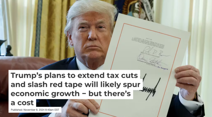 President Donald Trump holds up the 2017 tax law after signing it in the Oval Office of the White House in December 2017. AP Photo/Evan Vucci